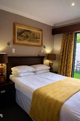 a bedroom with two beds and a painting on the wall at Aanmani Rose Guesthouse in Pretoria