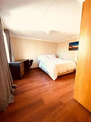 a bedroom with a bed and a desk in a room at Ka Tembe Self Catering Lodge in Polokwane