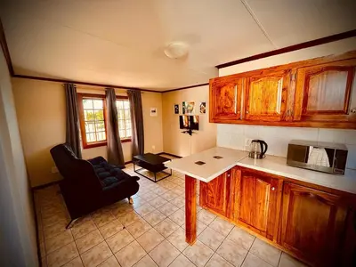 a kitchen with a table and a couch in a room at Ka Tembe Self Catering Lodge in Polokwane