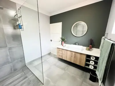 a bathroom with a sink and a shower at Afrique134 Olive Tree Private Courtyard Suite in Pretoria