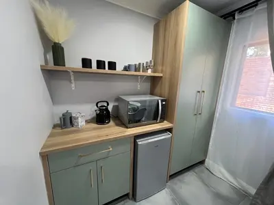 a small kitchen with a microwave on a counter at Afrique134 Olive Tree Private Courtyard Suite in Pretoria