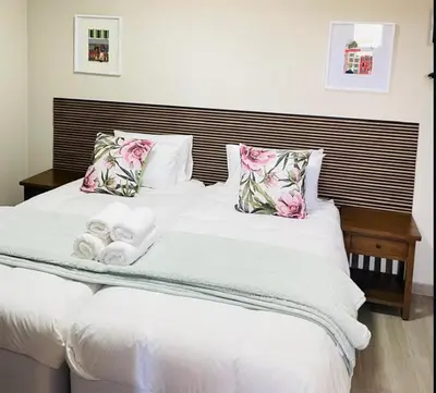 a white bed with two towels on top of it at Tintswalo Elegant Apartments in Giyani