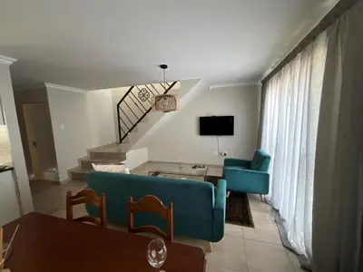 a living room with a blue couch and a table at Tintswalo Elegant Apartments in Giyani