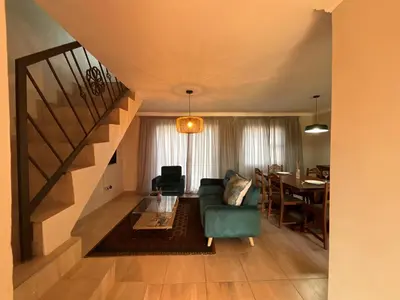 a living room with a blue couch and a table at Tintswalo Elegant Apartments in Giyani
