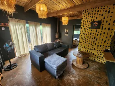 a living room with a couch and a chair at Hartbeest Bush Stay #3 in Hartbeespoort