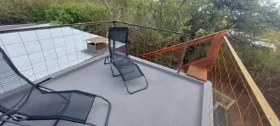 a balcony with two chairs and a bench on it at Hartbeest Bush Stay #3 in Hartbeespoort