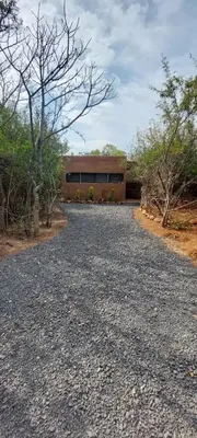 a gravel driveway with a building in the background at Hartbeest Bush Stay #3 in Hartbeespoort