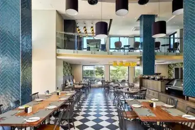 a restaurant with wooden tables and chairs and a checkered floor at Premier Lifestyle at The Regency in Pretoria