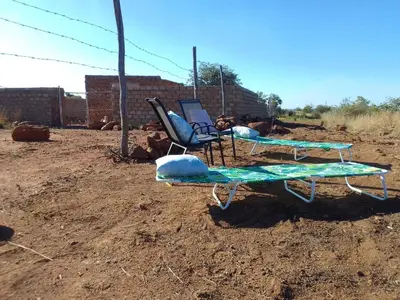 a couple of chairs and chairs in a dirt field at KGOLA SAFARIS in Rosslyn