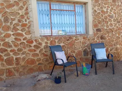two chairs sitting in front of a stone wall at KGOLA SAFARIS in Rosslyn