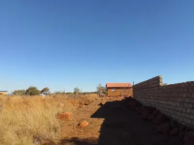 a brick wall next to a building in a field at KGOLA SAFARIS in Rosslyn