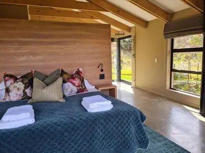 a bedroom with a large bed with two towels on it at Stone Cottage in Dullstroom
