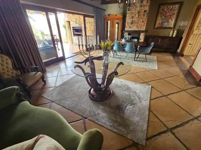 a living room with a vase with flowers on a table at Stone Cottage in Dullstroom