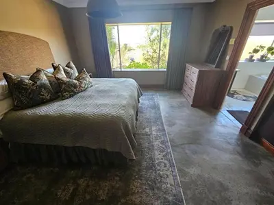 a bedroom with a bed and a tv and a window at Stone Cottage in Dullstroom