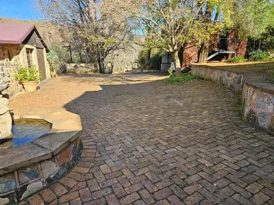 a brick driveway with a fountain in a yard at Stone Cottage in Dullstroom