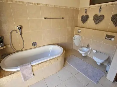 a bathroom with a tub and a toilet at Stone Cottage in Dullstroom