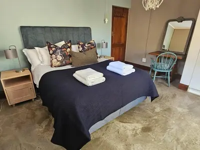a bedroom with a large bed with towels on it at Stone Cottage in Dullstroom