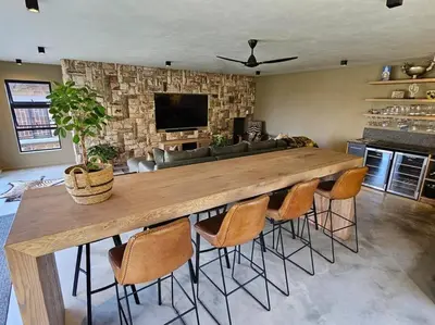 a large wooden table in a living room with chairs at Stone Cottage in Dullstroom