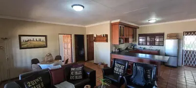 a kitchen and a living room with chairs and a counter at DullVino Apartment 8 at Millers Cove in Dullstroom