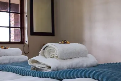 a pile of towels sitting on top of a bed at DullVino Apartment 8 at Millers Cove in Dullstroom
