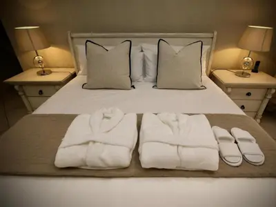 a bed with white towels and pillows on it at Decollage Estate in Polokwane