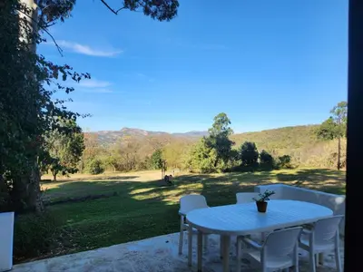 a table and chairs on a balcony with a view of a field at The Bardolino Artists Retreat in Nelspruit