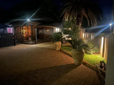 two large potted plants sitting in a courtyard at night at Seven Olives Guest Rooms in Thabazimbi