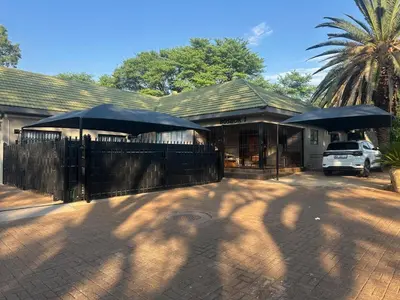 a house with two umbrellas in front of it at Seven Olives Guest Rooms in Thabazimbi