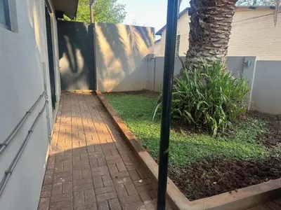 a walkway leading into a yard with a fence at Seven Olives Guest Rooms in Thabazimbi