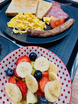 two plates of breakfast food with fruit and toast at Seven Olives Guest Rooms in Thabazimbi