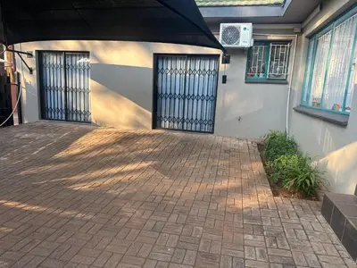 a building with two doors and a brick patio at Seven Olives Guest Rooms in Thabazimbi