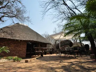 a hut with a table and an umbrella at Mokuru Private Nature Reserve in Brits
