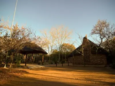 a building with a thatched roof in a park at Mokuru Private Nature Reserve in Brits