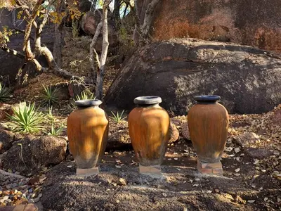 three vases sitting on rocks in a garden at Mokuru Private Nature Reserve in Brits
