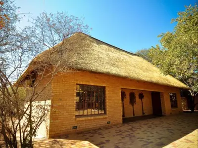 a small brick building with a thatched roof at Mokuru Private Nature Reserve in Brits