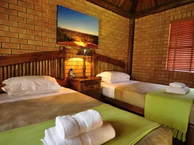 a bedroom with two beds and a tv on the wall at Mokuru Private Nature Reserve in Brits