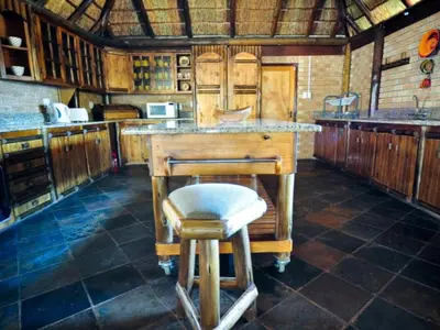 a kitchen with a counter and a stool in it at Mokuru Private Nature Reserve in Brits