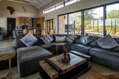 a living room with a couch and a table at Sihlangu Lodge in Marloth Park