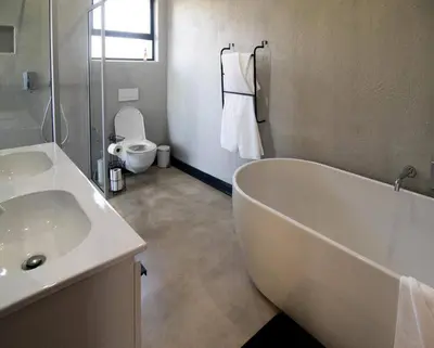 a bathroom with a tub and a sink and a toilet at Sihlangu Lodge in Marloth Park