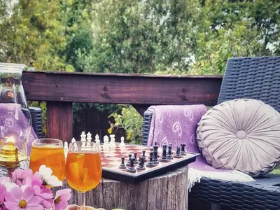 a chess game on a table with two glasses of beer at Cinnamon & Sage Country Cabins in Dullstroom