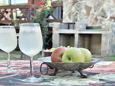 two glasses of water and a bowl of apples on a table at Cinnamon & Sage Country Cabins in Dullstroom