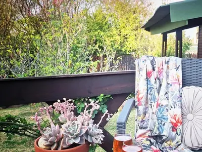 a balcony with a table with plants and a curtain at Cinnamon & Sage Country Cabins in Dullstroom