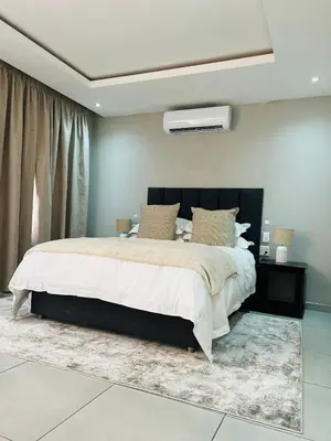 a bedroom with a large bed in a room at Elson Manor Guesthouse in Tzaneen