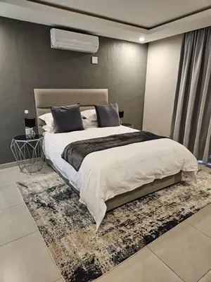 a bedroom with a large bed with a rug at Elson Manor Guesthouse in Tzaneen