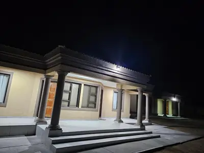 a building with columns and a light in the dark at Elson Manor Guesthouse in Tzaneen