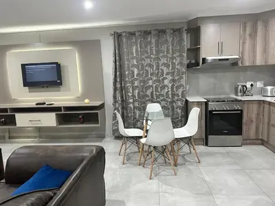 a living room with a couch and a kitchen at Nyeza homes in Secunda