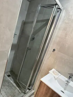 a shower with a glass door next to a sink at Nyeza homes in Secunda