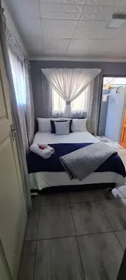 a bedroom with a large bed with a window at Cozy Little Nest in Pretoria