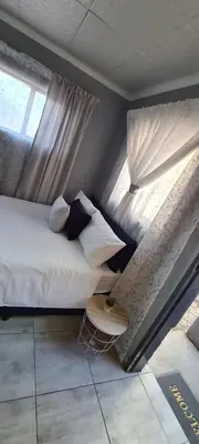 a bedroom with a bed and a window at Cozy Little Nest in Pretoria