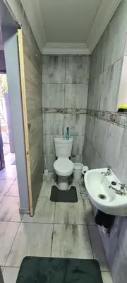 a bathroom with a toilet and a sink at Cozy Little Nest in Pretoria